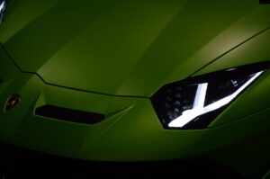 Close-up view of a green Lamborghini showcasing its sleek design and vibrant headlights.
